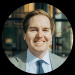 Professional man smiling in a suit, representing Bison Works' commitment to quality home improvement services and leather care expertise.