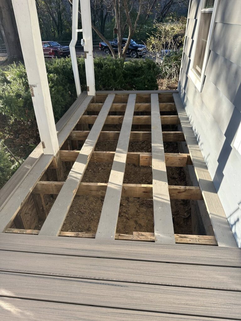 Deck renovation in progress, showcasing exposed wooden beams and structure beneath a porch, emphasizing home improvement and repair services by BisonWorks.
