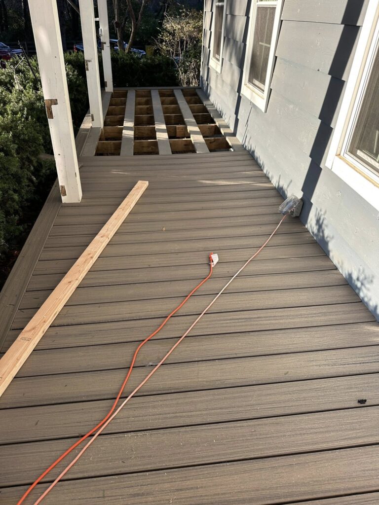 Decking in progress with exposed joists, electrical cord, and wooden plank, illustrating BisonWorks' home improvement services focused on quality roofing and structural integrity.