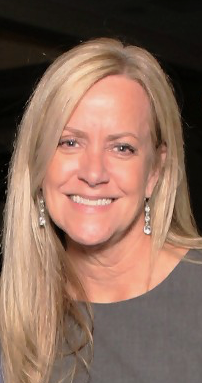 Jana Warner, interior designer at BisonWorks, smiling with long blonde hair and earrings, representing the integration of design expertise in home renovation projects.